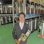 「古酒の文化を復活させたい」と意気込む匠創生の安村亮彦代表。後ろは古酒を貯蔵、熟成させているステンレス製容器＝加古川市野口町良野