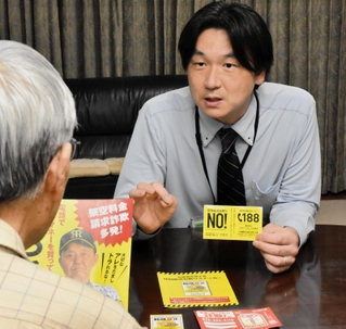 高齢者宅で特殊詐欺への注意を呼びかける地域包括支援センターの職員＝神戸市灘区