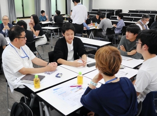 兵庫県立大の無償化をテーマに、社会人と意見を交わす生徒たち＝神戸市東灘区
