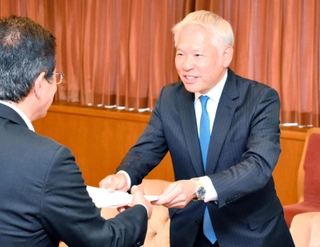 今西正男副市長（左）に報告書を手渡す中内仁検証チーム長＝神戸市役所