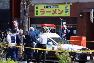 店内で男性が血を流して倒れていたラーメン店の周辺を調べる警察官＝２０２３年４月２２日、神戸市長田区東尻池町９