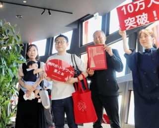 リニューアルオープン後、１０万人目の来場者となった竹内柚葉ちゃんと両親ら＝神戸市中央区波止場町