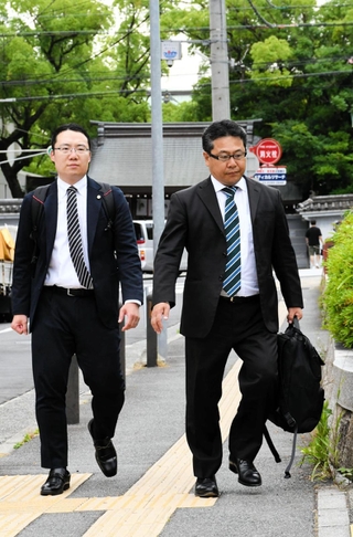 誤認逮捕の損害賠償を提訴するため、神戸地裁に入る女性の代理人弁護士＝１７日午後、神戸市中央区橘通２