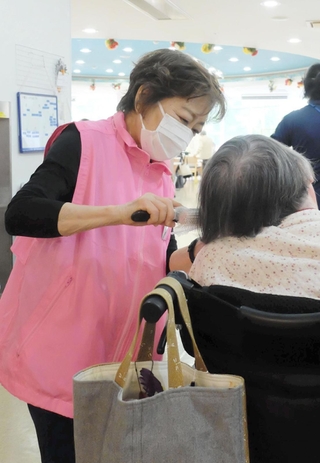 高齢者ケアの補助を担う福地啓子さん。組合名の「ヘルパント」はエスペラント語の「助っ人」から＝神戸市灘区青谷町２、デイサービスセンターあおたに