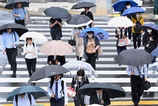 傘を差し、職場や学校などへ向かう人たち＝２１日午前、神戸市中央区雲井通６（撮影・大田将之）