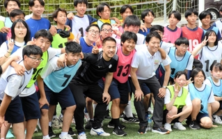 記念撮影に納まる岡崎慎司さん（前列左から４人目）＝神戸市西区平野町印路