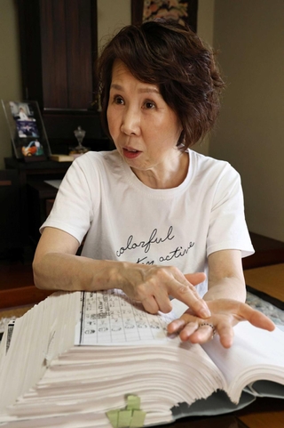 公務災害申請のため集めた膨大な資料を手元に、当時を振り返る森川えみさん＝神戸市垂水区（撮影・長嶺麻子）
