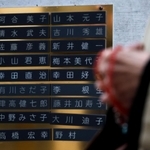 阪神・淡路大震災の４日後に亡くなった父親・幸田直治さんと母親・好子さんの銘板を訪れる雅子さん＝神戸市中央区加納町６、東遊園地（撮影・長嶺麻子）