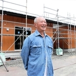 集落への思いを語る左部淳一さん。後ろは、被災地で唯一建設が進む「ふるさと回帰型応急仮設住宅」＝石川県穴水町下唐川