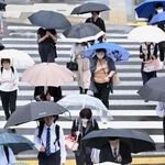 傘を差し、職場や学校などへ向かう人たち＝２１日午前、神戸市中央区雲井通６（撮影・大田将之）