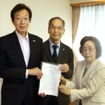 過労死防止法の成立１０年に合わせ、さらなる対策を求めて久元喜造市長（左）に要望書を手渡す西垣迪世さん（右）ら＝神戸市役所
