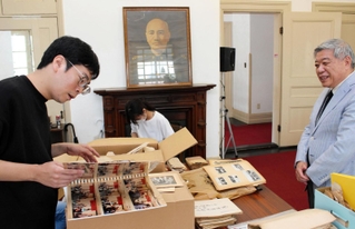 「中華民国留日神戸華僑総会」の８０周年記念誌の制作に向け、資料整理に当たる葉翔太さん（左）と江丕正さん（右）ら＝いずれも神戸市中央区北野町４