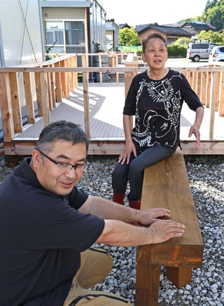 仮設住宅で知り合った井田幸長さん（左）と加賀竹美さん。ボランティアが製作したベンチに腰かけ、世間話を交わす＝石川県七尾市中島町（撮影・長嶺麻子）