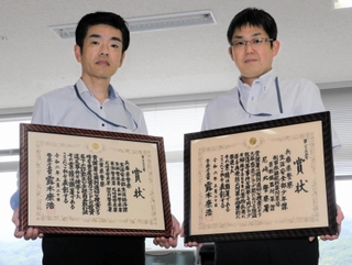 警察庁長官賞の賞状を持つ（左から）兵庫県警生活経済課の北垣俊雄次席と少年課の森川正臣課長補佐＝県警本部
