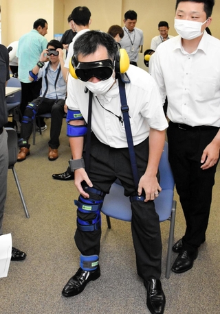 専用の器具などを使って高齢者の疑似体験をする警察官ら＝兵庫県警本部