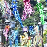 七夕飾りで彩られた商店街で、日傘を差して歩く人たち。地面には「逃げ水」現象も＝４日午前、神戸市須磨区の須磨寺前商店街（撮影・風斗雅博）