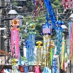 七夕飾りで彩られた商店街を歩く人たち。強い日差しから逃れようと日傘を差す人の姿が多く見られた＝４日午前、神戸市須磨区の須磨寺前商店街（撮影・風斗雅博）