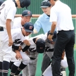 試合中に足をつった選手を支えるチームメートら＝豊岡市戸牧、豊岡こうのとり球場