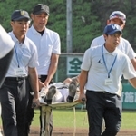 試合中に足をつり、担架で運ばれる選手＝豊岡市戸牧、豊岡こうのとり球場