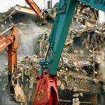 阪神・淡路大震災で被災後、重機で解体されるビル。粉じんが舞う＝１９９５年２月、神戸市兵庫区