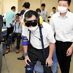 専用の器具などを使って高齢者の疑似体験をする警察官ら＝兵庫県警本部