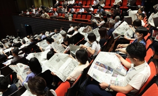 ＮＩＥ全国大会では持ち寄った新聞を回し読みし、意見を交わす時間も設けられた＝１日午後、京都市左京区、ロームシアター京都