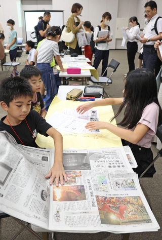 公開授業で自分たちで作った新聞と実際の報道を見比べる児童たち＝２日午後、京都市下京区、京都経済センター