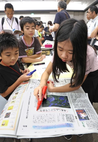 公開授業で自分たちで作った新聞と実際の報道を見比べる児童たち＝２日午後、京都市下京区、京都経済センター