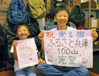 １００山制覇の喜びに浸る日高崇さん（右）と樹ちゃん＝明石市大久保町駅前２