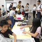 公開授業で自分たちで作った新聞と実際の報道を見比べる児童たち＝２日午後、京都市下京区、京都経済センター