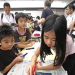 公開授業で自分たちで作った新聞と実際の報道を見比べる児童たち＝２日午後、京都市下京区、京都経済センター
