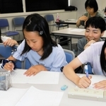 感想文を書く子どもたちを見守る和氣光代さん（左端）と岸本くるみさん（左から３人目）＝神戸新聞社（撮影・杉山雅崇）