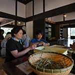 風通しがよい古民家の室内で野草茶作りを体験する親子連れら＝神戸市北区山田町藍那、あいな里山公園