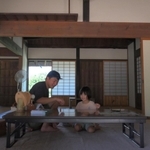 風通しがよい古民家の室内でコマ遊びをする親子連れ＝神戸市北区山田町藍那、あいな里山公園