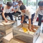 タイムカプセルから収納物を取り出す宝塚市職員ら＝宝塚市武庫川町、市立文化芸術センター
