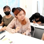 日本語学校の留学生と話しながら日本での生活や困ったことなどを聞き取る神戸学院大の学生（右から２人目）ら＝神戸市内