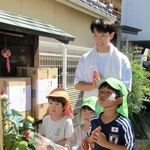 神戸母子寮跡地の地蔵に、訪れた子どもたちと手を合わせる鈴木佑一さん＝２３日午後、神戸市兵庫区湊川町10