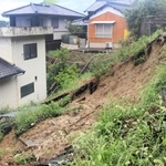 地域の集会所（左）のそばで土砂が崩れた＝30日午後２時52分、南あわじ市阿那賀（撮影・劉　楓音）