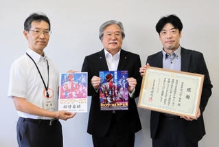 目録を受け取った岡田英樹福祉部長（左）と、感謝状を受け取った山中英夫専務理事（中央）とポップサーカスの下垣純プロジェクトリーダー＝兵庫県庁