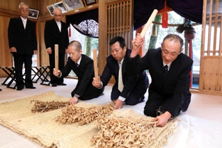 「大豊年」の掛け声に合わせて大豆の束をたたく当人の供人＝御形神社