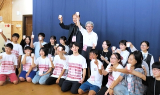 「豊岡演劇祭２０２４」の開幕を祝い、中高生らと乾杯をする平田オリザ氏（後列右から４人目）＝６日午後、豊岡市日高町