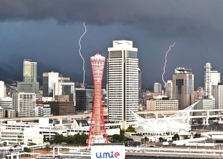夕方の空を切り裂くように走る稲妻＝１２日午後、神戸市中央区東川崎町１から大阪方面を望む