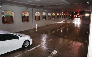 一時冠水したアンダーパスと水没した乗用車（手前）＝１２日午後６時２４分、芦屋市大原町