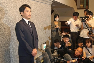 不信任決議案の可決直後、詰めかけた報道陣の取材に応じる斎藤元彦知事＝19日午後、神戸市中央区、県公館（撮影・岩崎昂志）