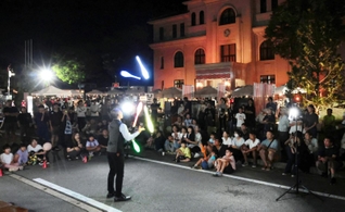 「豊岡演劇祭２０２４」の夜市で、妙技を披露する大道芸人＝２２日午後、豊岡市中央町