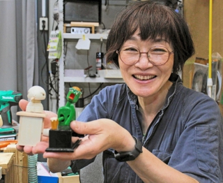 神戸人形の代表作「ビール河童（かっぱ）」（右）などを手にする吉田綾さん＝神戸市東灘区住吉山手８