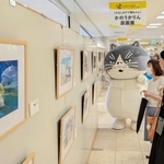 かなしきデブ猫ちゃんの原画３８点が並ぶ会場。会場にはマルが登場した＝神戸阪急