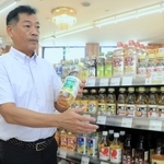 商品の瓶を手に震災時の対応を話す橋本昌俊さん＝マイマルシェ洲本とれたて市場