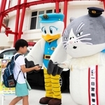 一日署長を務めるデブ猫のマル（右）と兵庫県警のマスコットキャラクターこうへいくん（中央）＝神戸市中央区波止場町