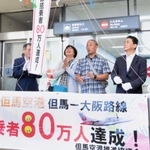 搭乗80万人目となった榎並光治さん（右から３人目）と妻万里子さん（同４人目）＝但馬空港